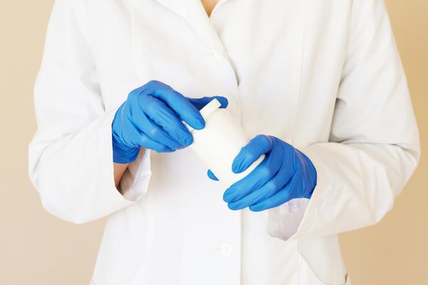 Farmacéutico con bata blanca y guantes azules